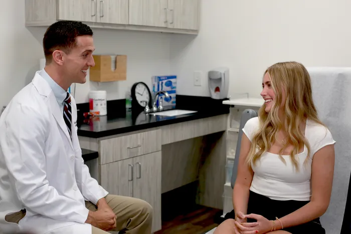 Dr. Hudson explaining rosacea treatment to a patient
